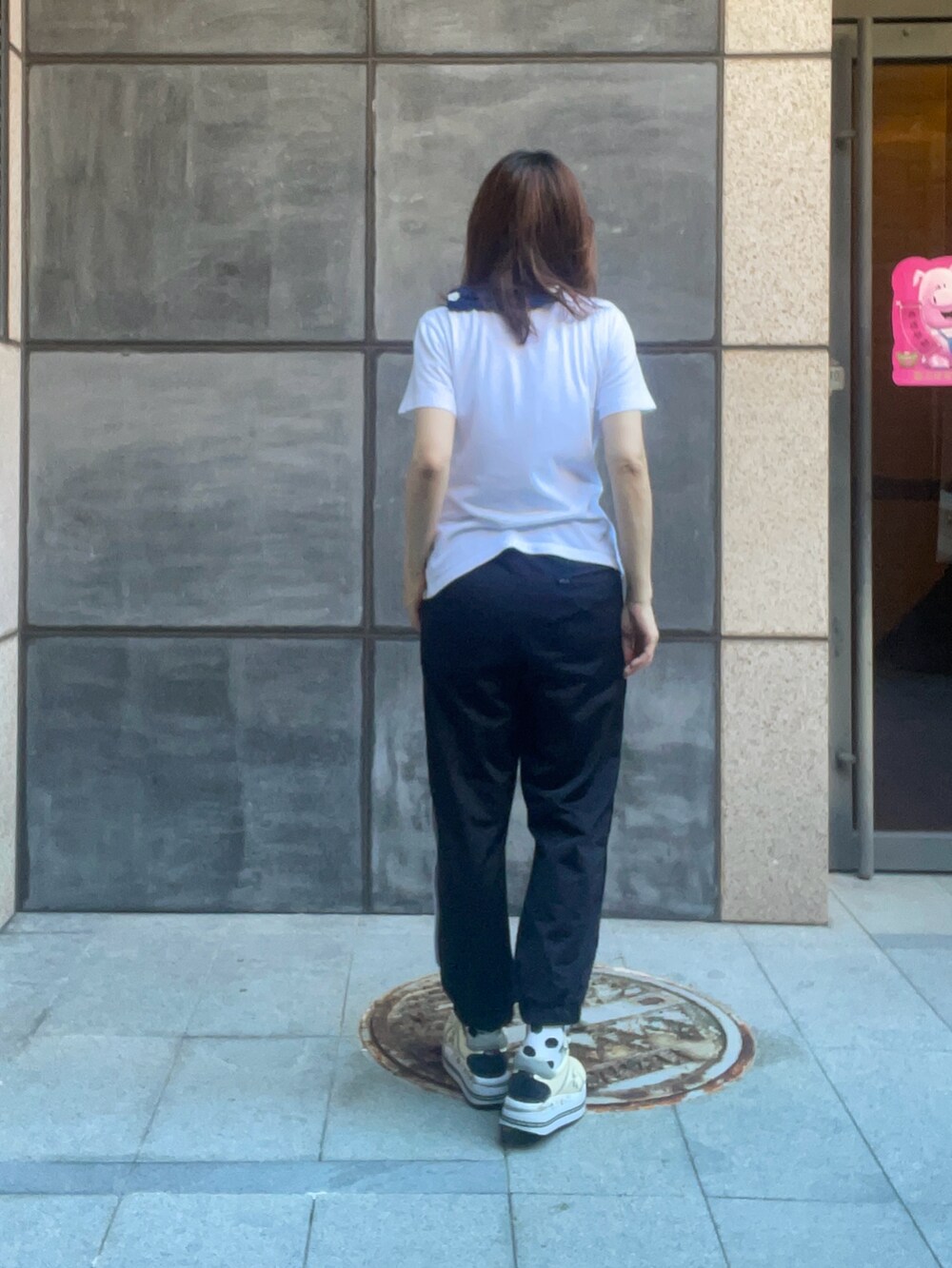 ブラック系のチノパンツ、ホワイト系のTシャツ/カットソー、ベージュ系のスニーカーを着用したレディースの冬コーディネートの3枚目の写真