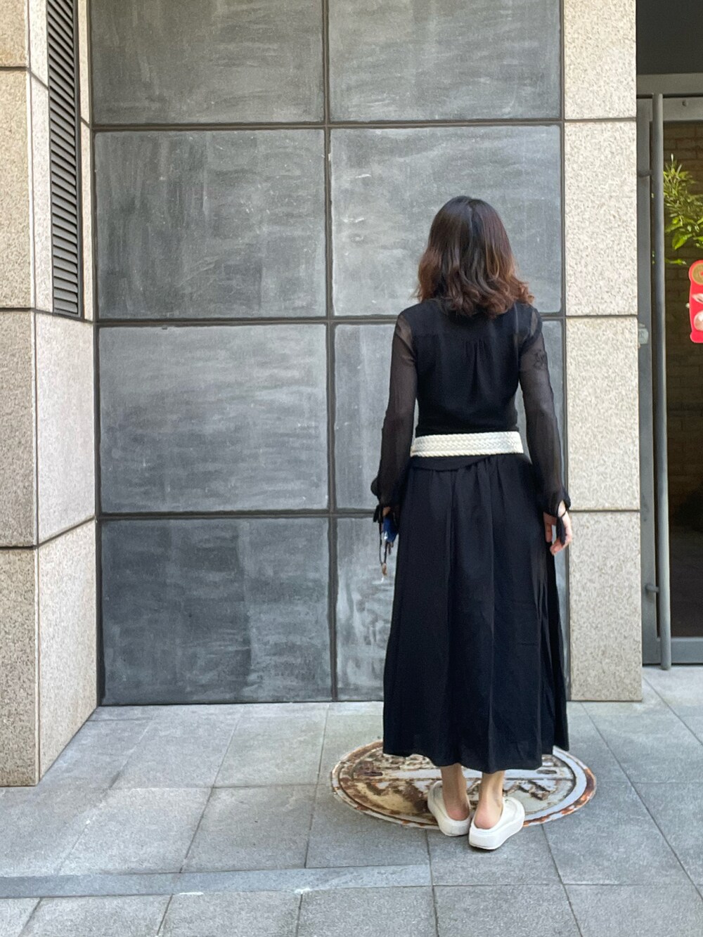 ブラック系のシャツ/ブラウス、ブラック系のスカート、ベージュ系のスリッポンを着用したレディースの夏コーディネートの2枚目の写真