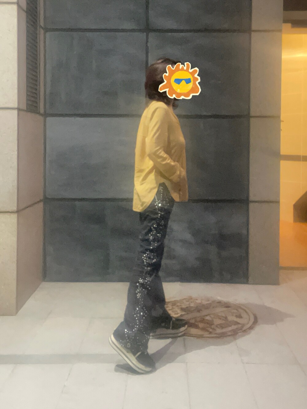 ブラック系のデニムパンツ、オレンジ系のシャツ/ブラウス、ブラック系のスニーカーを着用したレディースの夏コーディネートの3枚目の写真