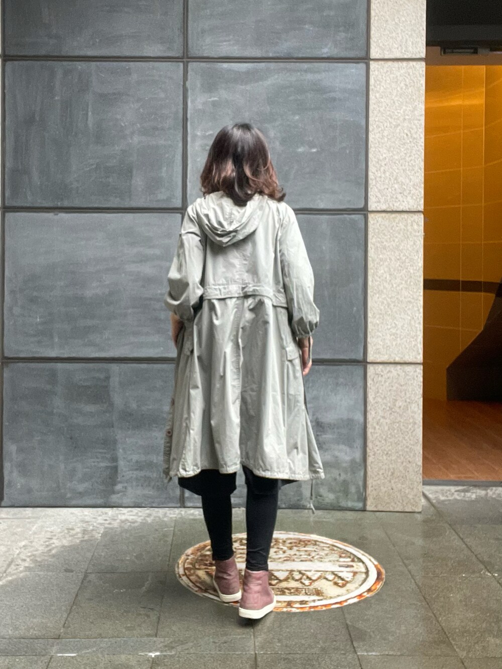 グレー系のTシャツ/カットソー、ブラック系のチノパンツ、グリーン系のトレンチコートを着用したレディースの春コーディネートの4枚目の写真