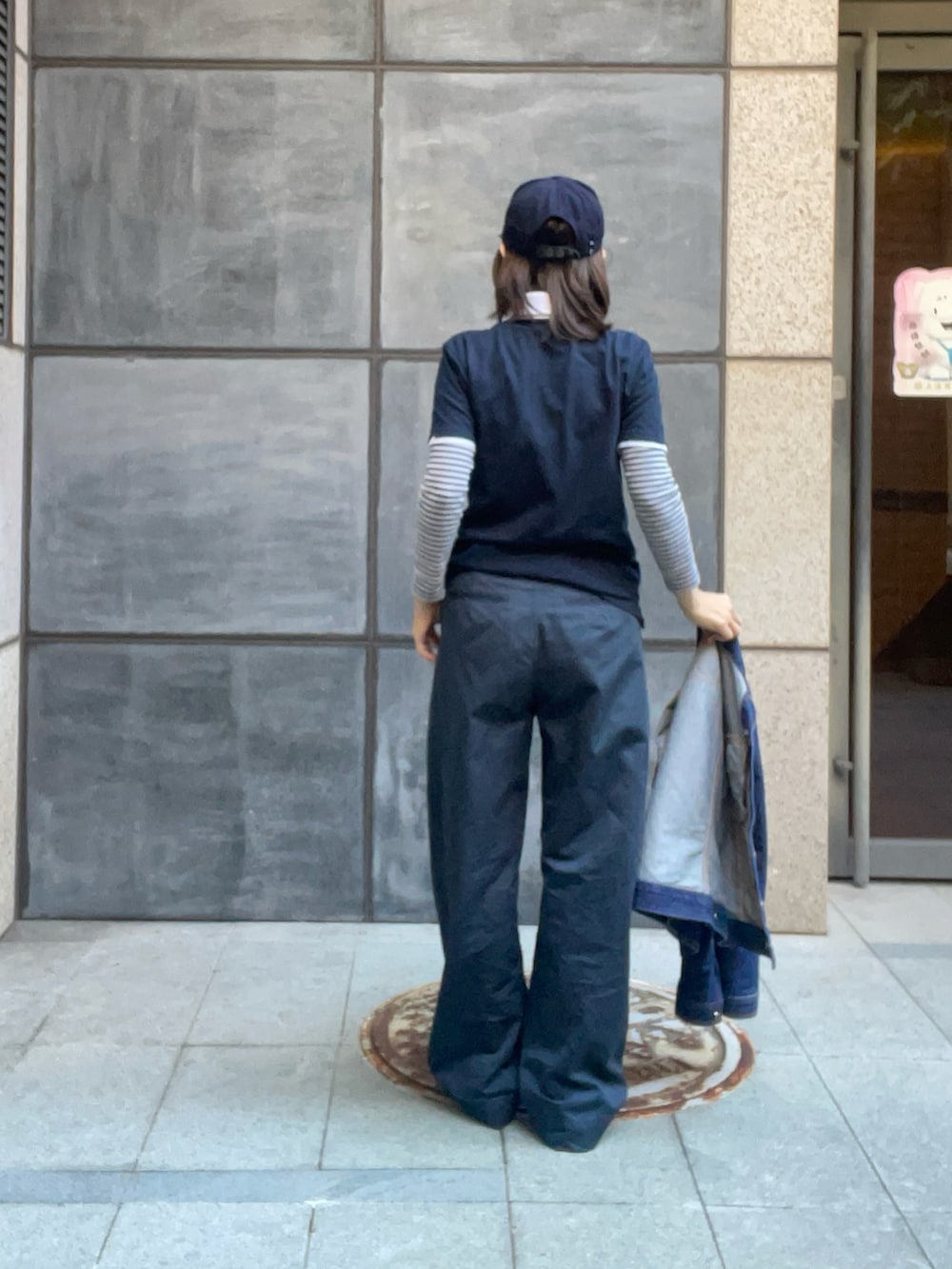 ブルー系のポロシャツ、ブルー系のチノパンツ、ホワイト系のスニーカーを着用したレディースの秋コーディネートの3枚目の写真