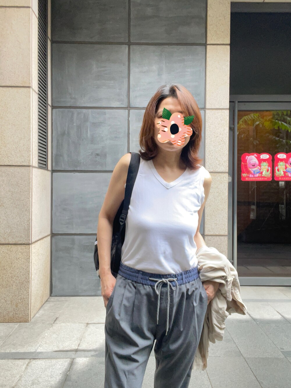 ホワイト系のタンクトップ、ベージュ系のジャケット/アウター、グレー系のチノパンツを着用したレディースの春コーディネートの3枚目の写真