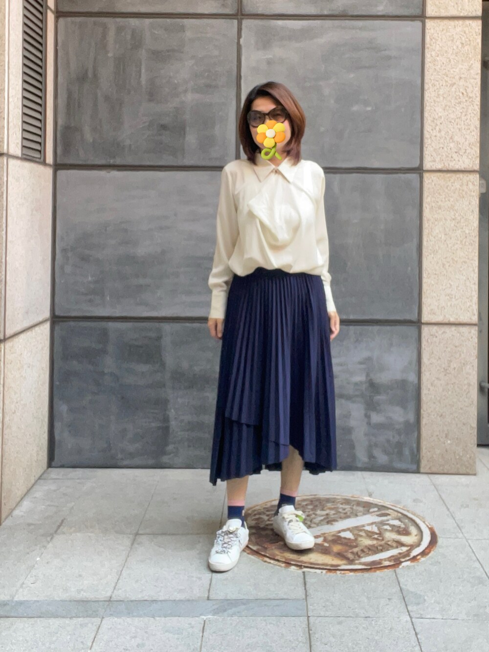 ベージュ系のビジネスシャツ、ホワイト系のテーラードジャケット、ブルー系のスカートを着用したレディースの秋コーディネートの2枚目の写真