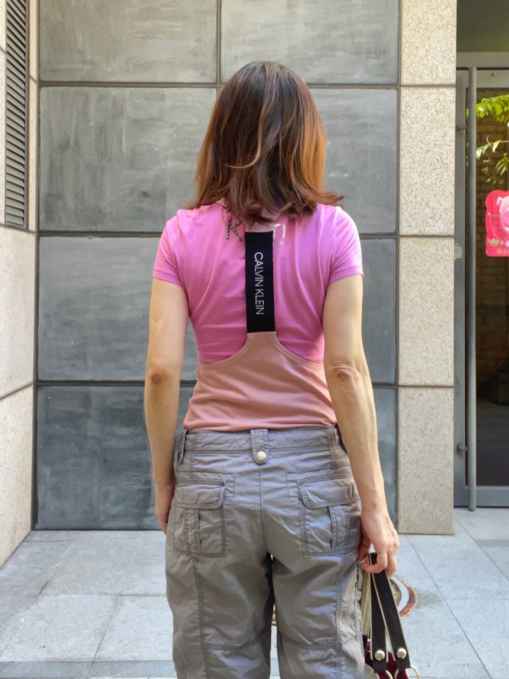ピンク系のTシャツ/カットソー、グレー系のカーゴパンツ、ベージュ系のレインシューズを着用したレディースの夏コーディネートの2枚目の写真