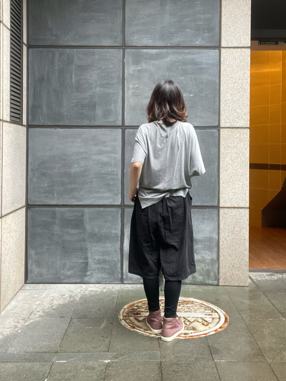 グレー系のTシャツ/カットソー、ブラック系のチノパンツ、グリーン系のトレンチコートを着用したレディースの春コーディネートの5枚目の写真