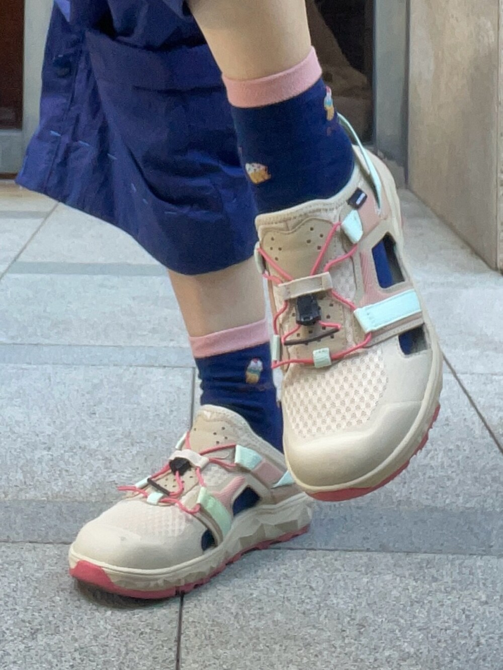 レッド系のポロシャツ、ブルー系のつなぎ/オールインワン、ベージュ系のレインシューズを着用したレディースの秋コーディネートの4枚目の写真