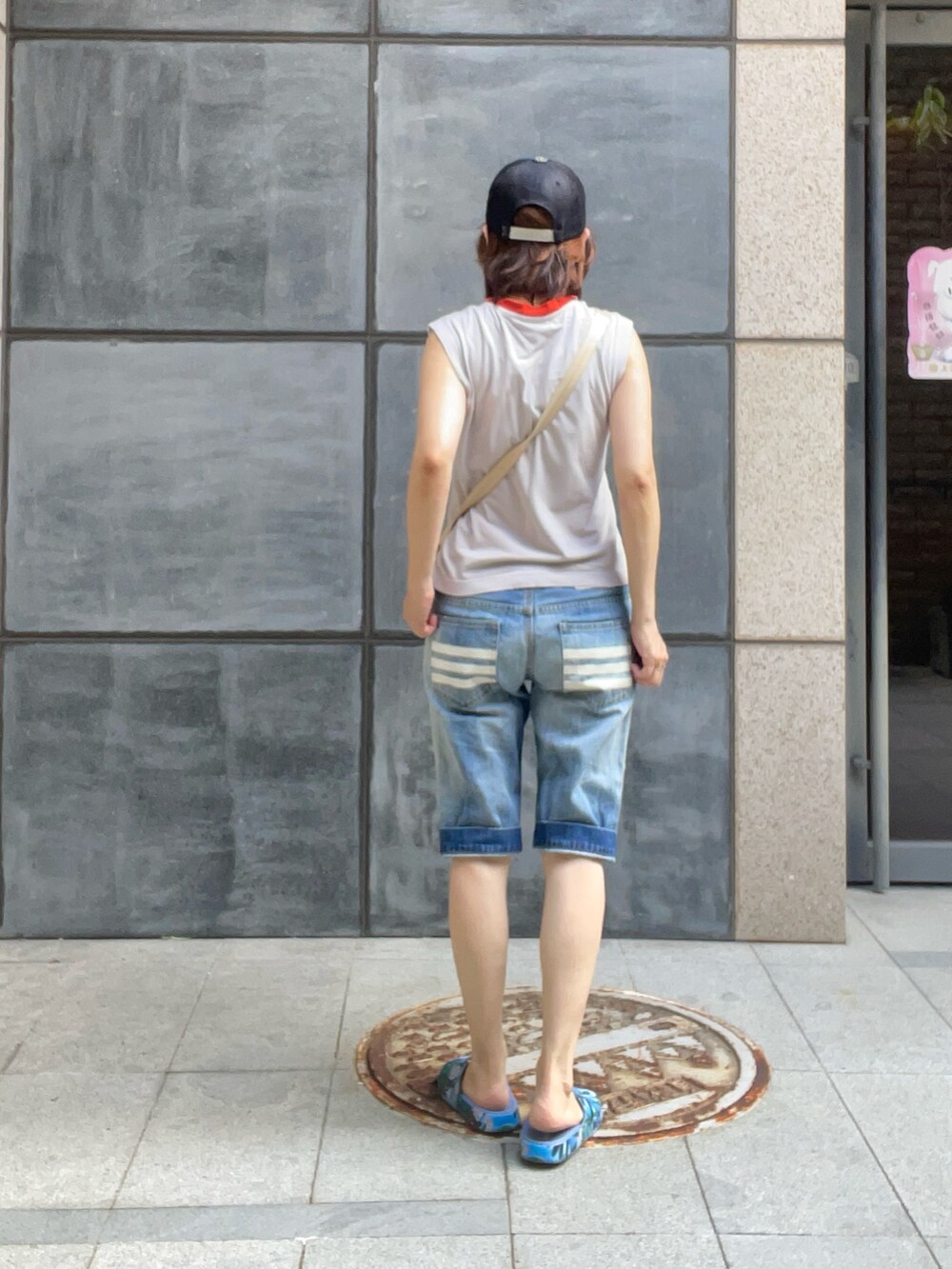 シルバー系のポロシャツ、ブルー系のビーチサンダル、ブルー系のデニムパンツを着用したレディースの秋コーディネートの4枚目の写真