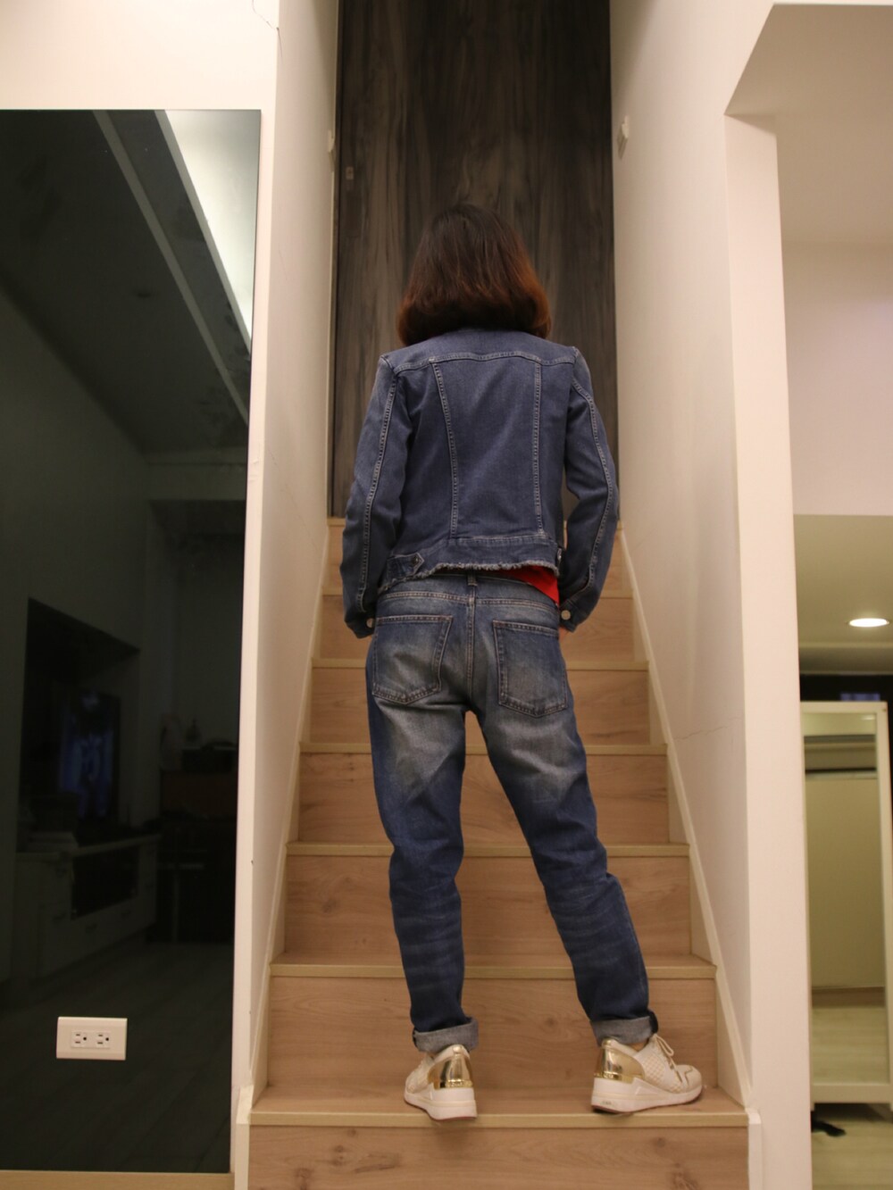 ブルー系のデニムジャケット、レッド系のトップス、ブルー系のデニムパンツを着用したレディースの春コーディネートの3枚目の写真