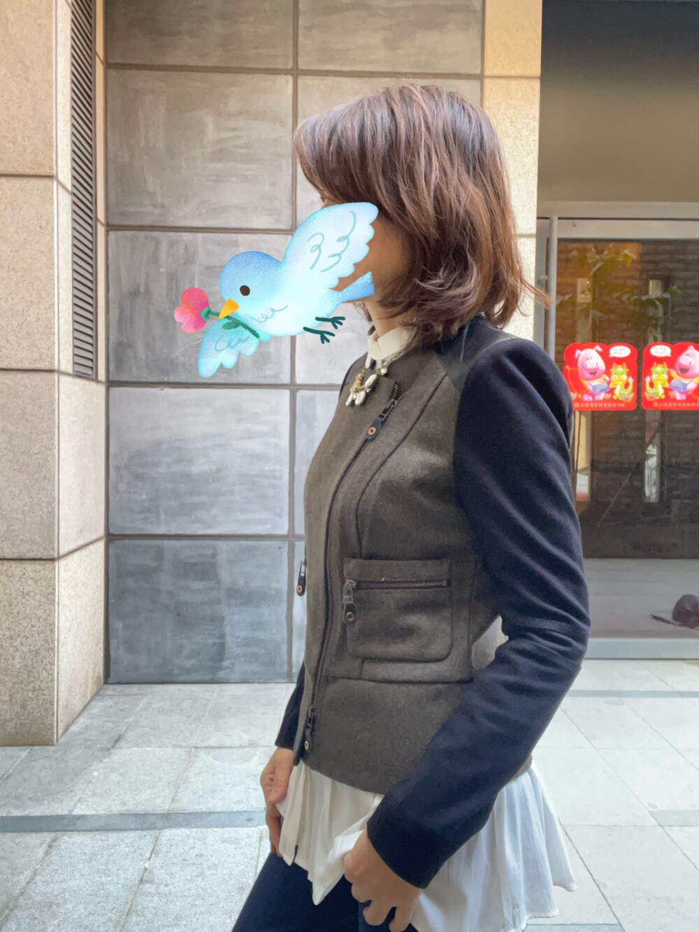グレー系のノーカラージャケット、ホワイト系のシャツ/ブラウス、ブルー系のスラックスを着用したレディースの春コーディネートの2枚目の写真