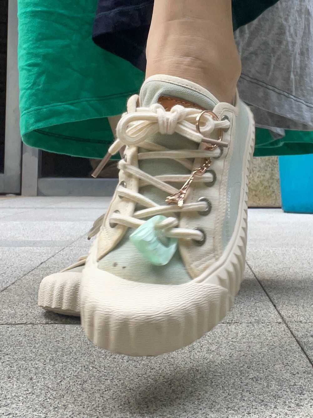 グリーン系のチュニック、グリーン系のスニーカー、グレー系のモッズコートを着用したレディースの秋コーディネートの5枚目の写真