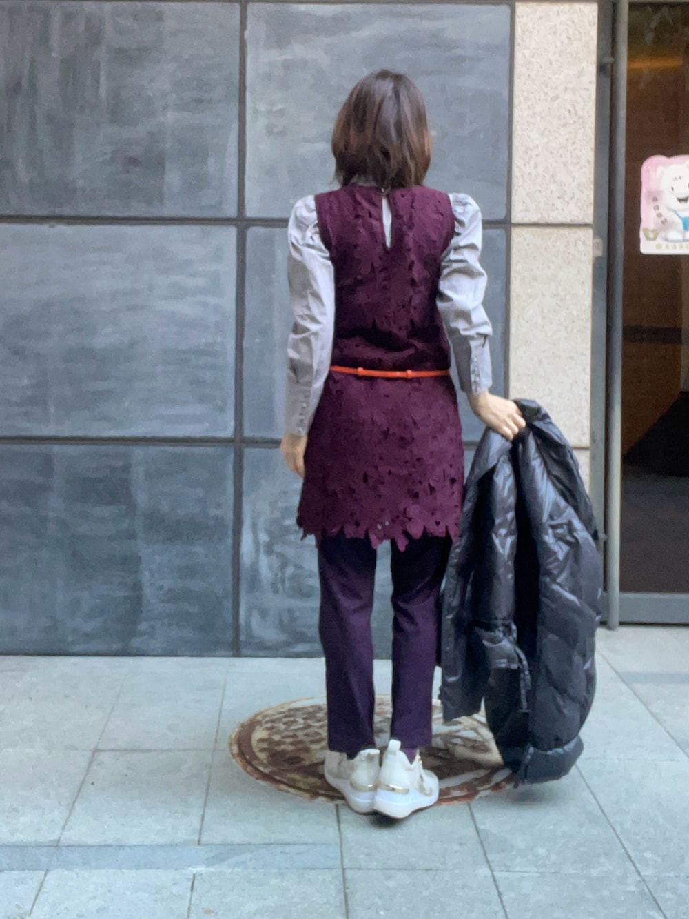 グレー系のダウンジャケット/コート、レッド系のワンピース、ベージュ系のスニーカーを着用したレディースの冬コーディネートの3枚目の写真