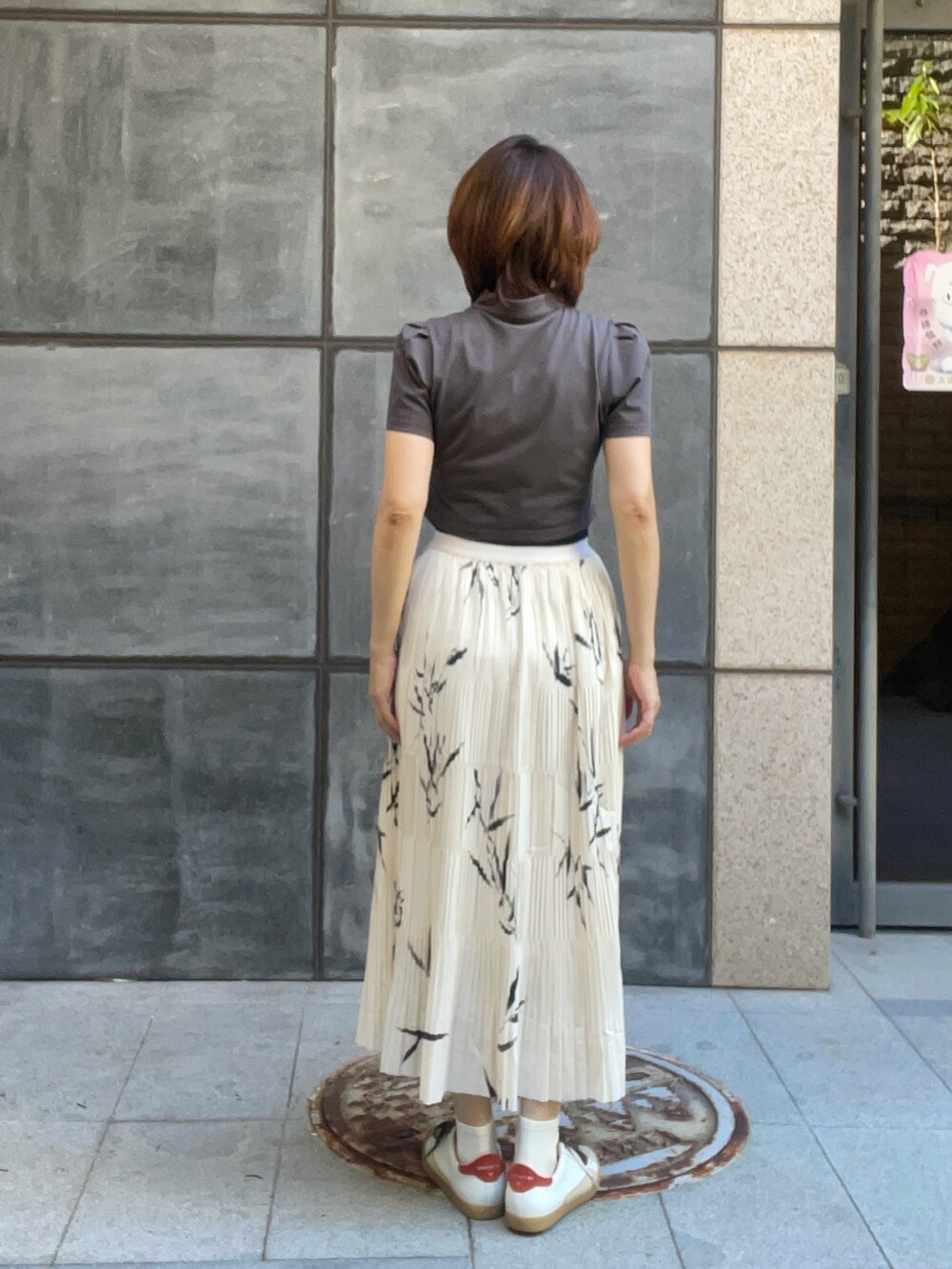 ホワイト系のスニーカー、グリーン系のTシャツ/カットソー、ベージュ系のスカートを着用したレディースの夏コーディネートの3枚目の写真