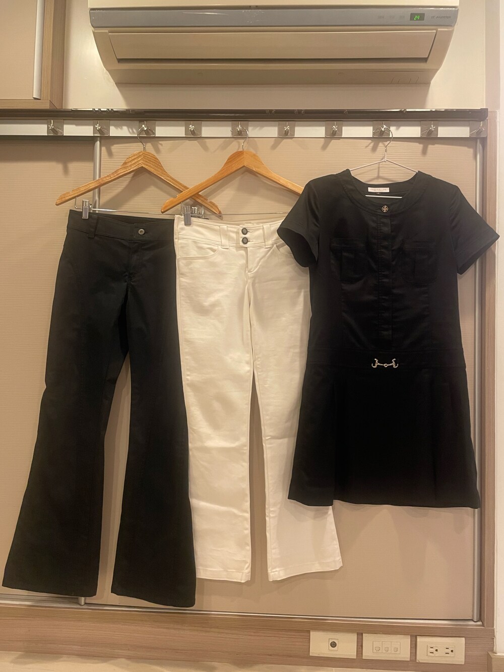 ブラック系のチュニック、ブラック系のスラックス、ホワイト系のデニムパンツを着用したレディースの春コーディネートの3枚目の写真