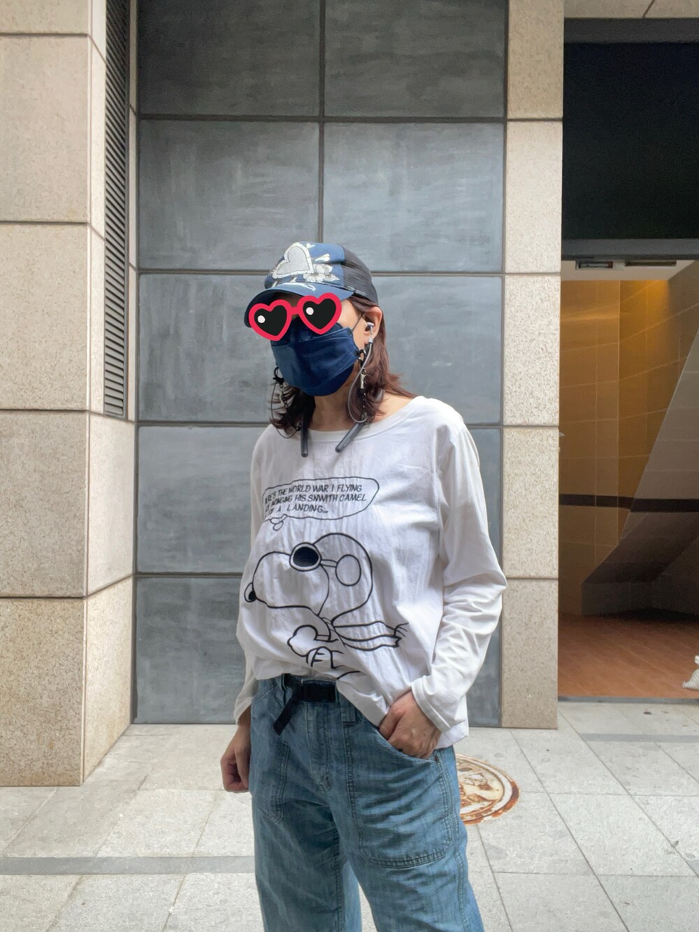 ブルー系のデニムパンツ、ホワイト系のスニーカー、ブルー系のキャップを着用したレディースの春コーディネートの3枚目の写真