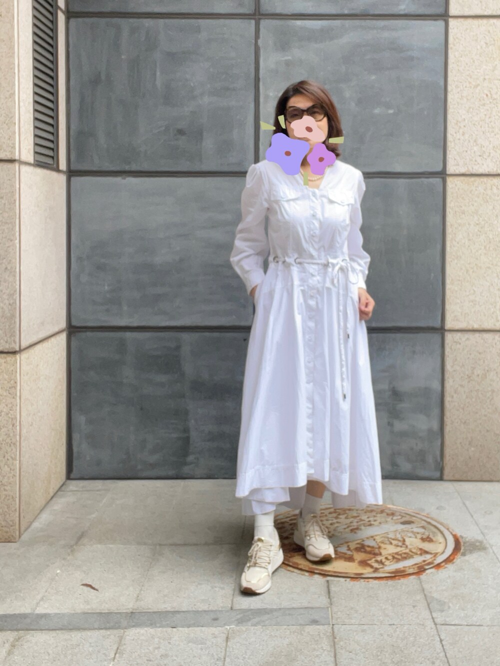 ベージュ系のスニーカー、ホワイト系のシャツワンピース、ブラウン系のサングラスを着用したレディースの春コーディネートの3枚目の写真