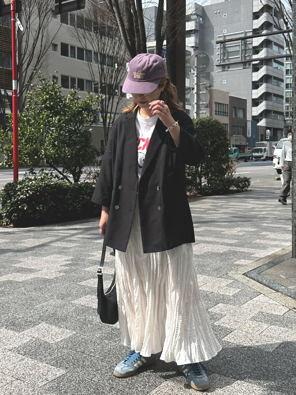 ブラック系のテーラードジャケット、ホワイト系のスカート、ホワイト系のTシャツ/カットソーを着用したレディースの春コーディネートの3枚目の写真