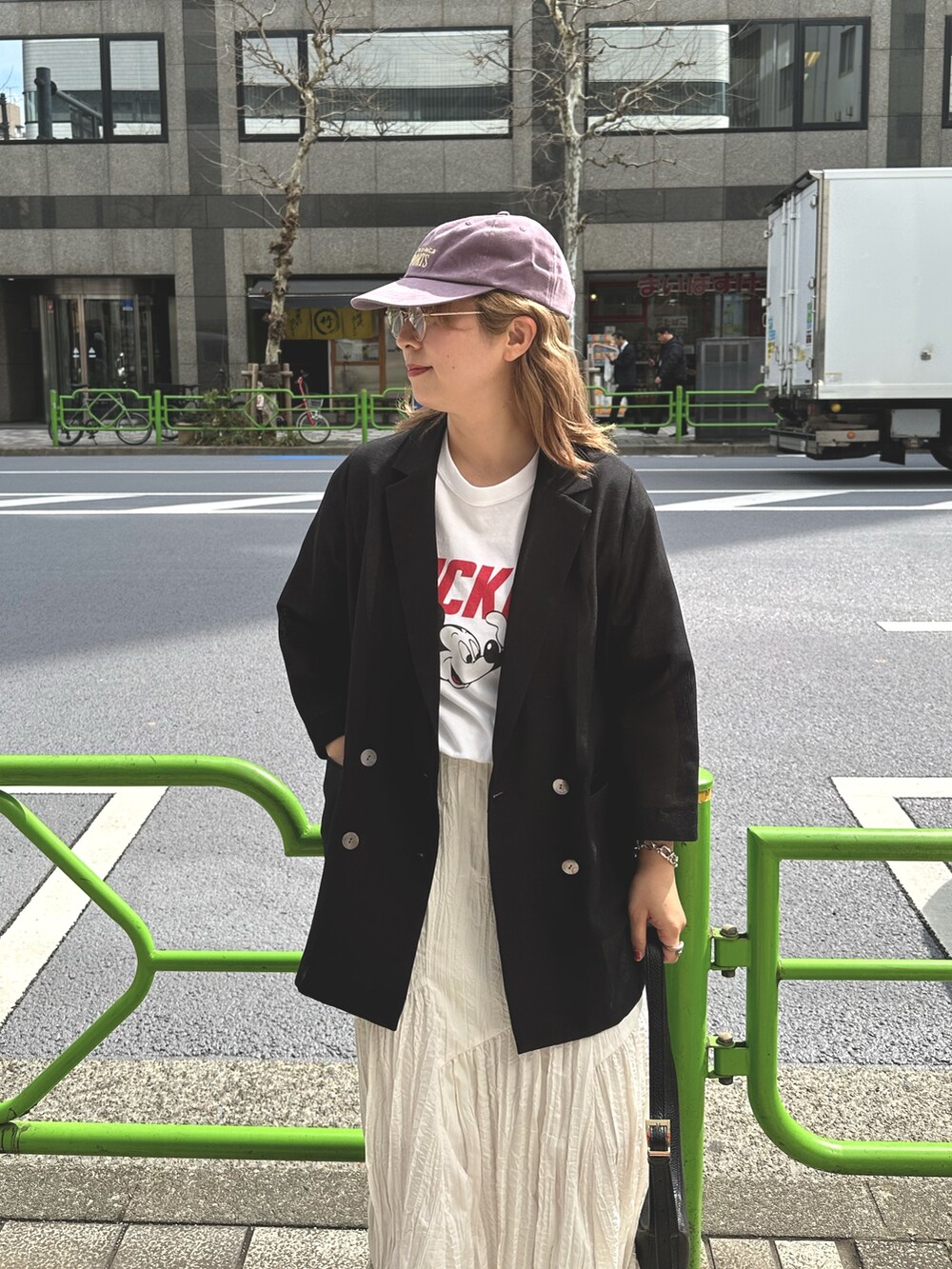 ブラック系のテーラードジャケット、ホワイト系のスカート、ホワイト系のTシャツ/カットソーを着用したレディースの春コーディネートの2枚目の写真