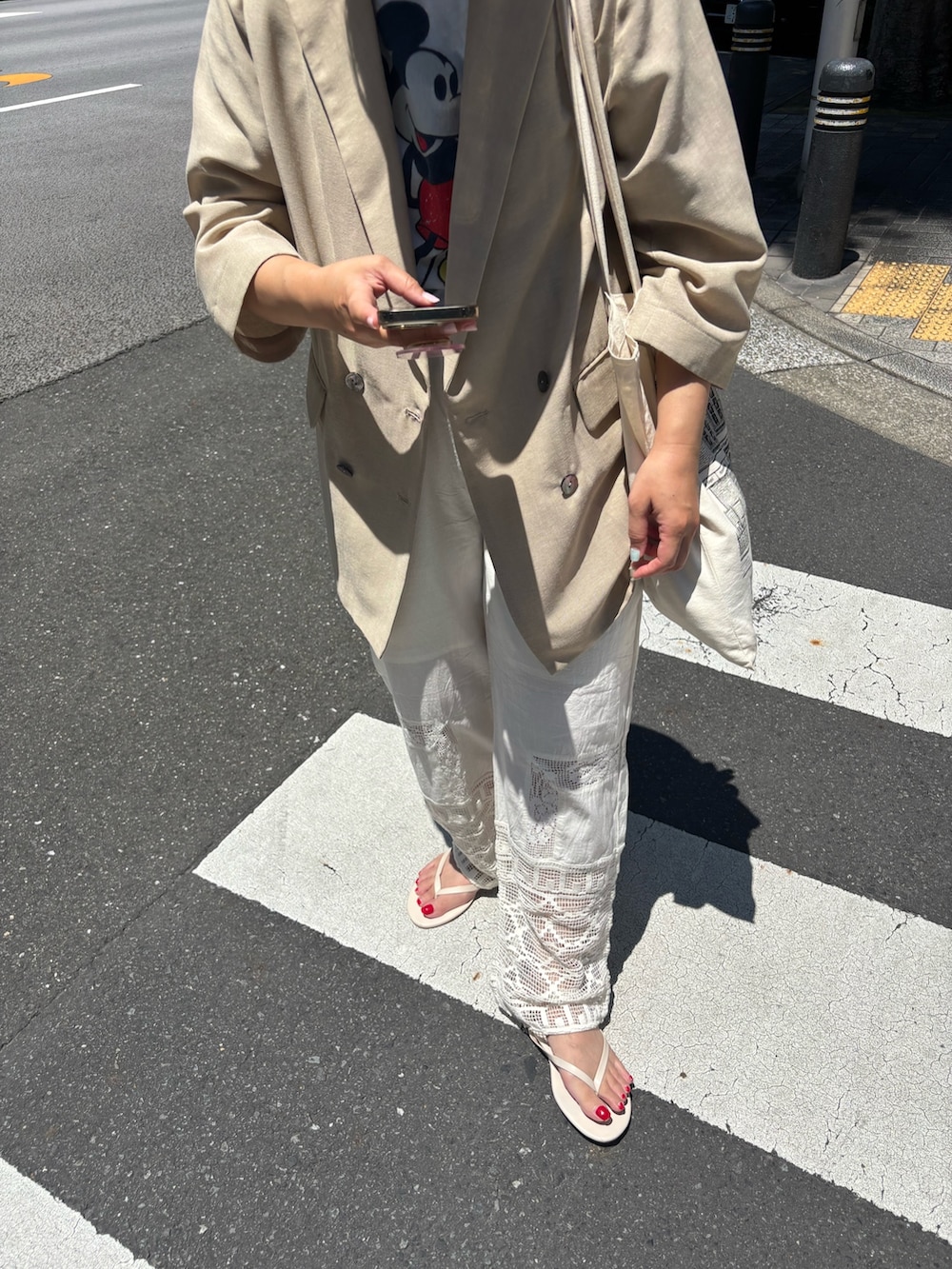 ベージュ系のテーラードジャケット、ホワイト系のその他パンツ、ブルー系のキャップを着用したレディースの夏コーディネートの2枚目の写真