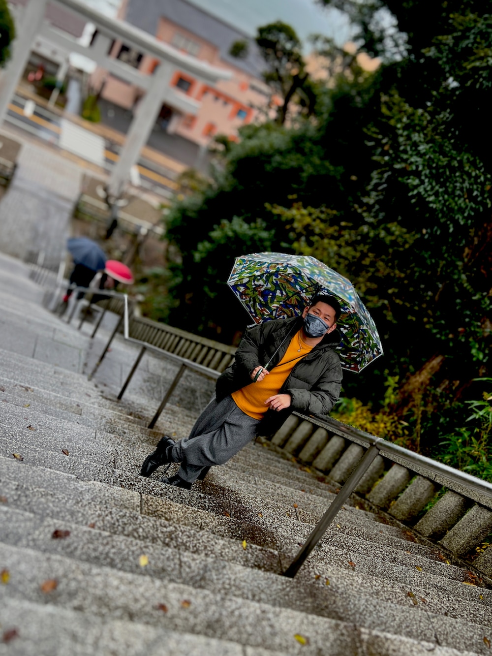 イエロー系のニット/セーター、グリーン系のジャケット/アウター、グレー系のパンツを着用したメンズの秋コーディネートの2枚目の写真