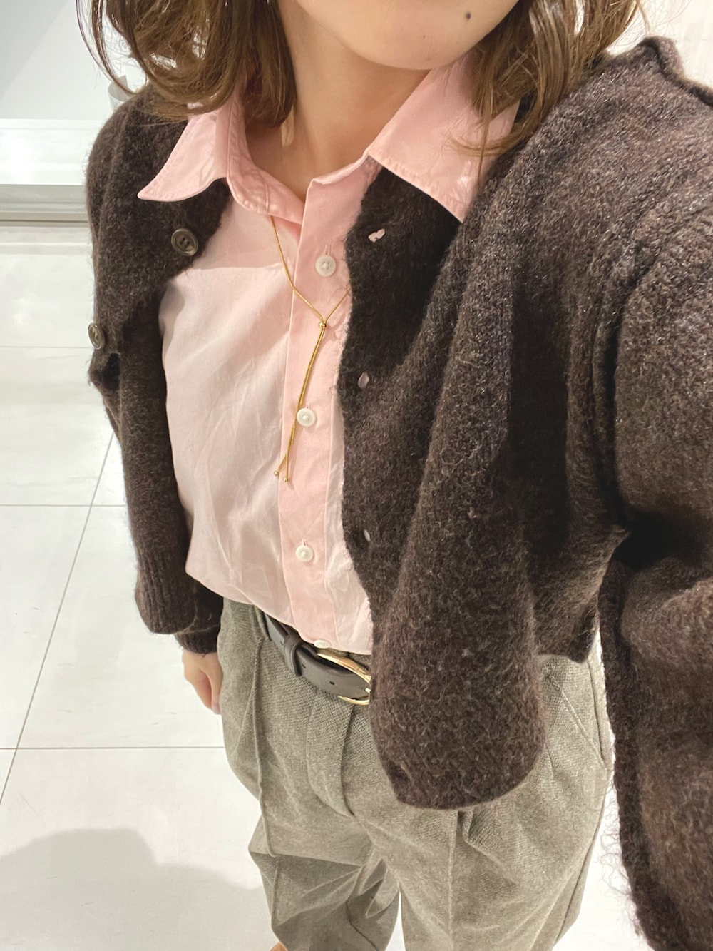 ベージュ系のパンツ、ピンク系のシャツ/ブラウス、ブラウン系のカーディガン/ボレロを着用したレディースの冬コーディネートの3枚目の写真