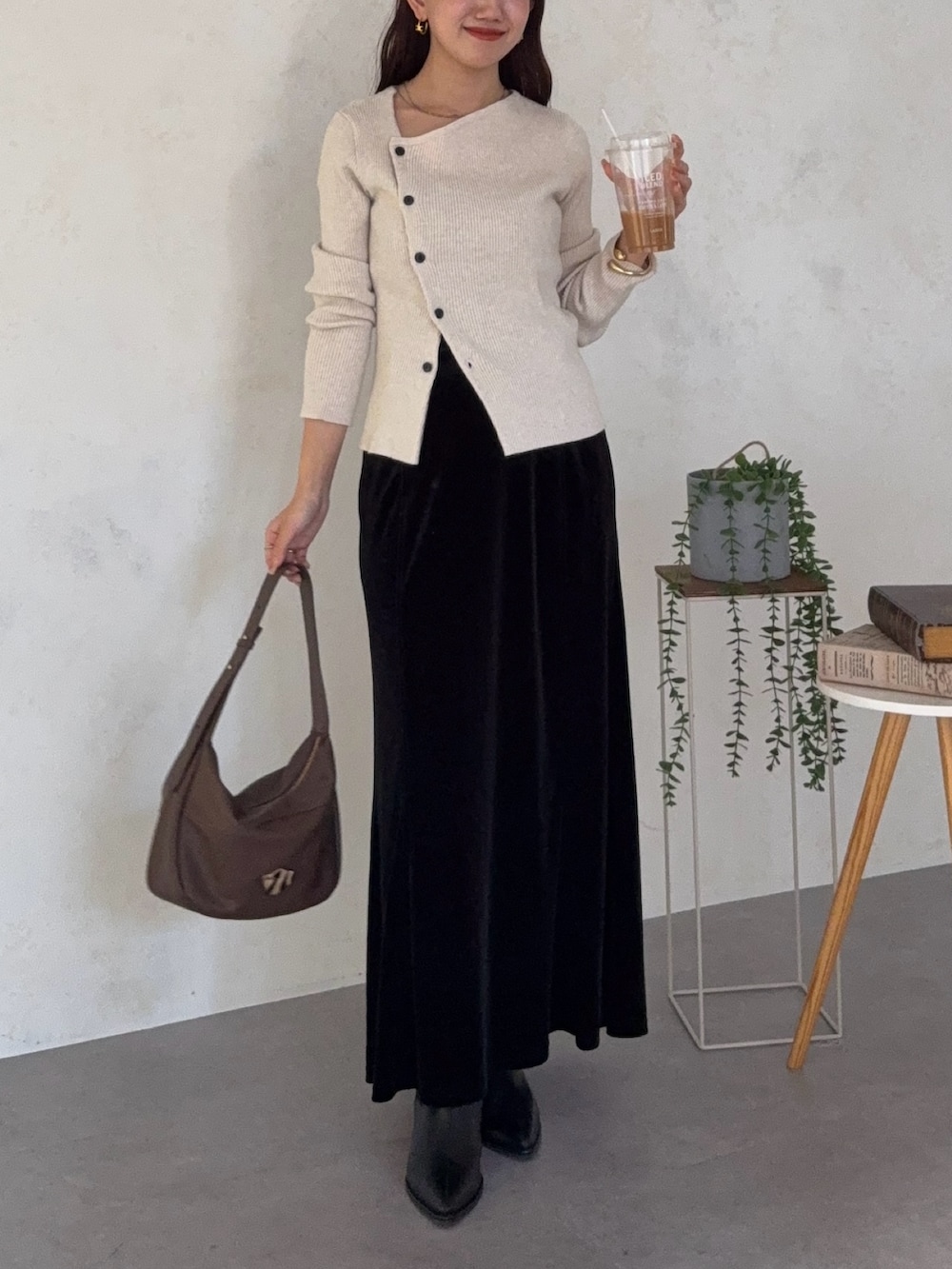 ホワイト系のニット/セーター、ブラック系のスカート、ブラック系のブーツを着用したレディースの秋コーディネートの3枚目の写真