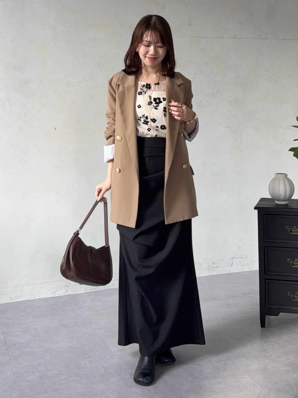 ベージュ系のテーラードジャケット、ホワイト系のシャツ/ブラウス、ブラック系のスカートを着用したレディースの春コーディネートの2枚目の写真