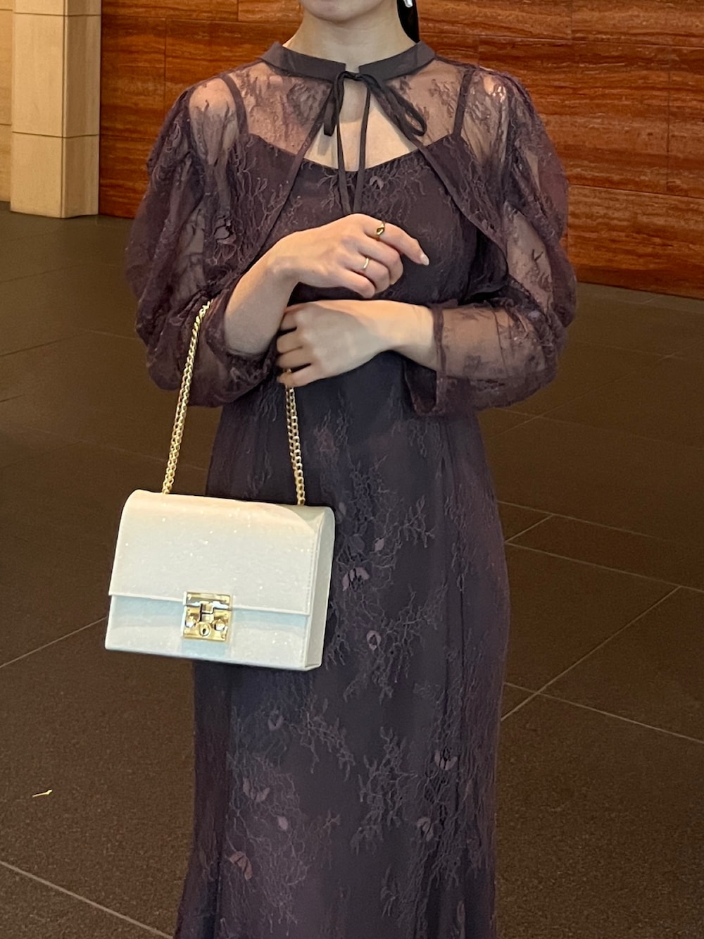 グレー系のドレス、ベージュ系のハンドバッグを着用したレディースの冬コーディネートの2枚目の写真