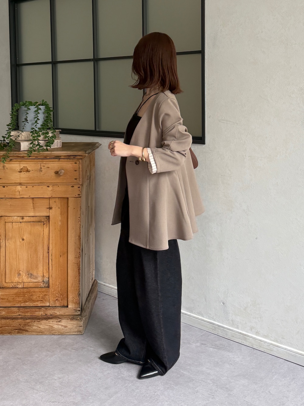 ベージュ系のテーラードジャケット、ブラック系のキャミソール、ブラック系のデニムパンツを着用したレディースの春コーディネートの3枚目の写真