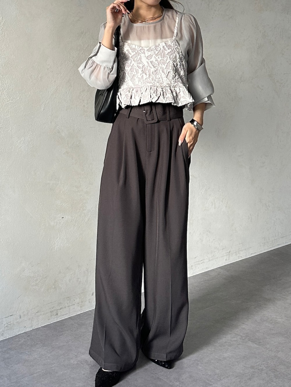 グレー系のシャツ/ブラウス、グレー系のスラックス、ブラック系のパンプスを着用したレディースの夏コーディネートの3枚目の写真