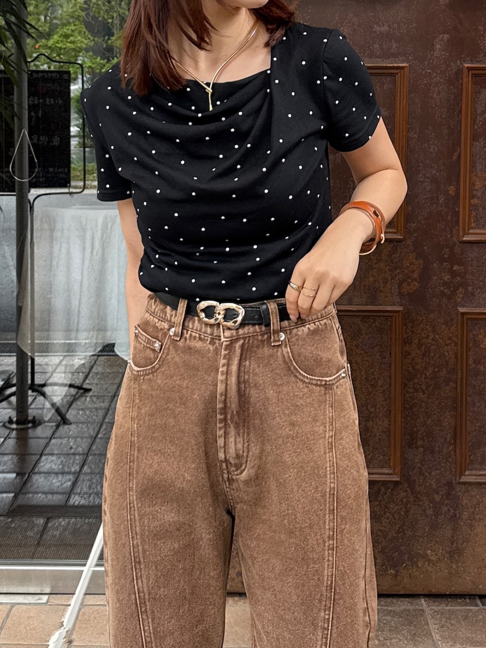 ブラック系のTシャツ/カットソー、ブラウン系のデニムパンツ、ブラック系のサンダルを着用したレディースの夏コーディネートの3枚目の写真