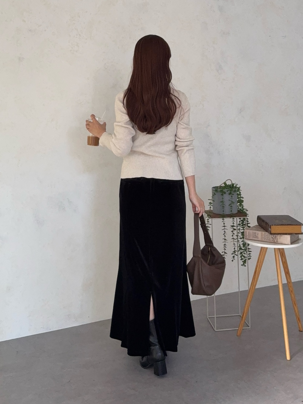 ホワイト系のニット/セーター、ブラック系のスカート、ブラック系のブーツを着用したレディースの秋コーディネートの2枚目の写真