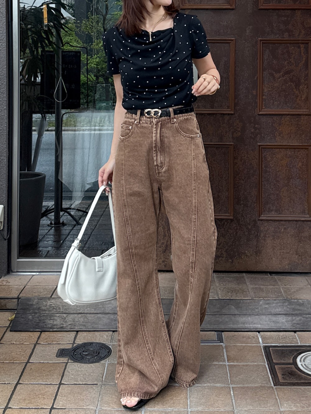 ブラック系のTシャツ/カットソー、ブラウン系のデニムパンツ、ブラック系のサンダルを着用したレディースの夏コーディネートの2枚目の写真