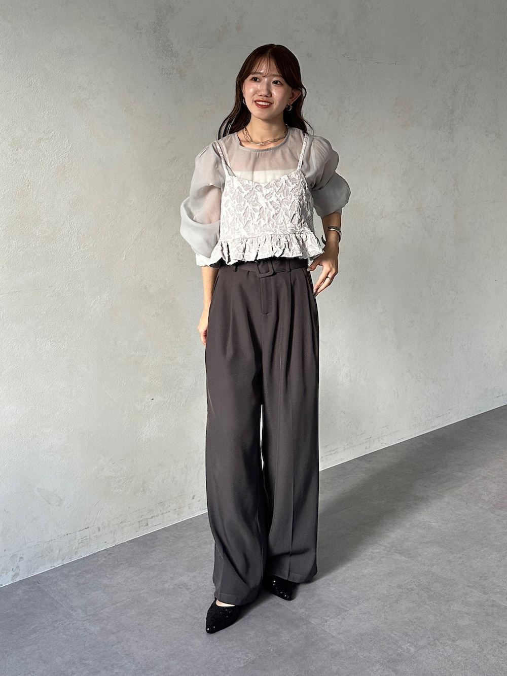 グレー系のシャツ/ブラウス、グレー系のスラックス、ブラック系のパンプスを着用したレディースの夏コーディネートの2枚目の写真