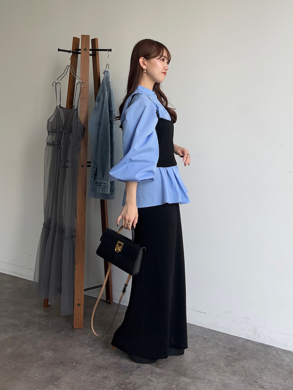 ブルー系のシャツ/ブラウス、ブラック系のスカート、ブラック系のショルダーバッグを着用したレディースの冬コーディネートの2枚目の写真