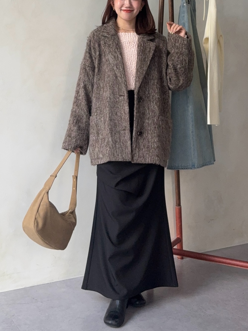 ブラウン系のその他アウター、ピンク系のニット/セーター、ブラック系のスカートを着用したレディースの冬コーディネートの2枚目の写真