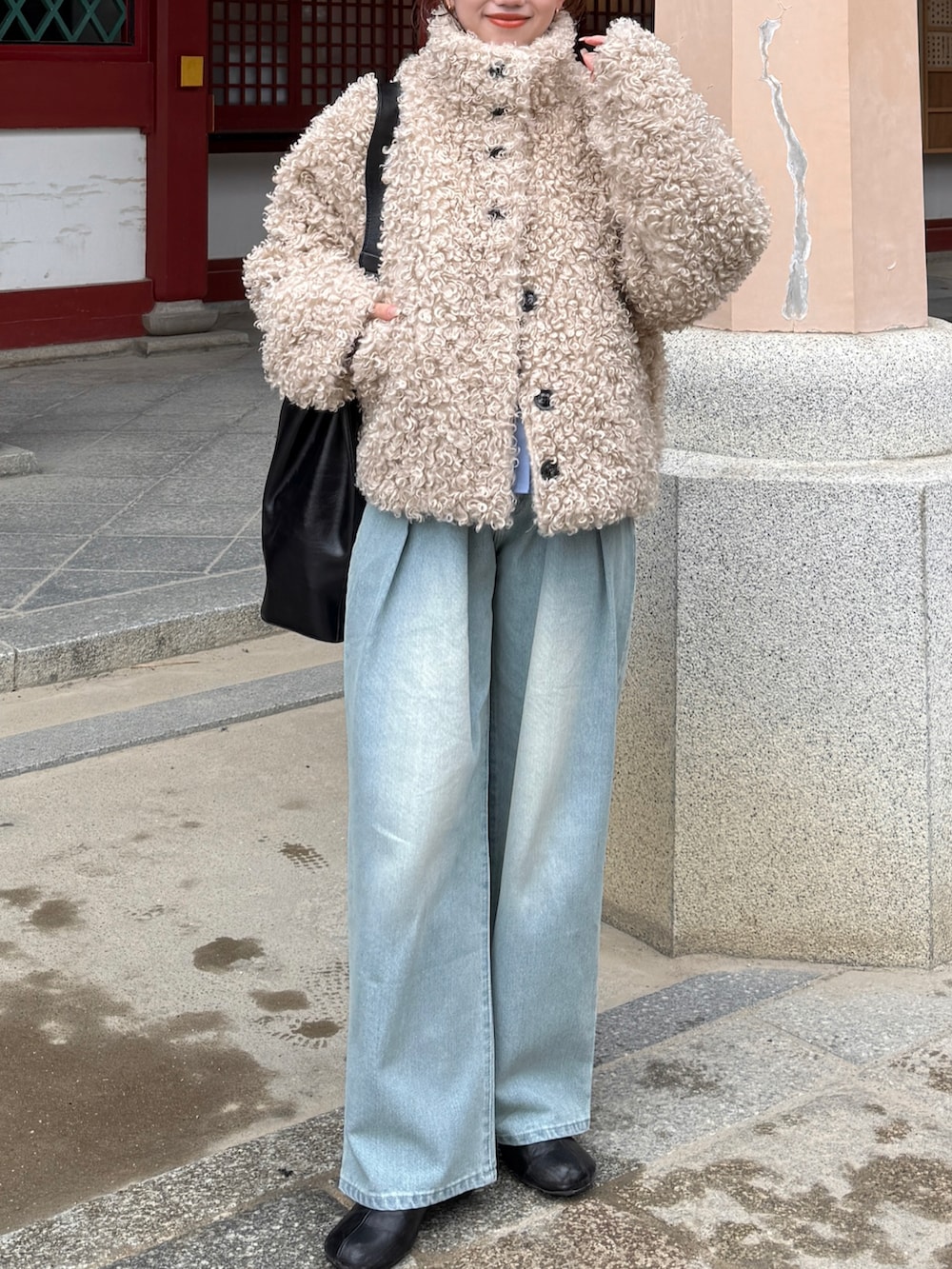 グレー系のニット/セーター、ブルー系のデニムパンツ、ホワイト系のブルゾンを着用したレディースの冬コーディネートの3枚目の写真