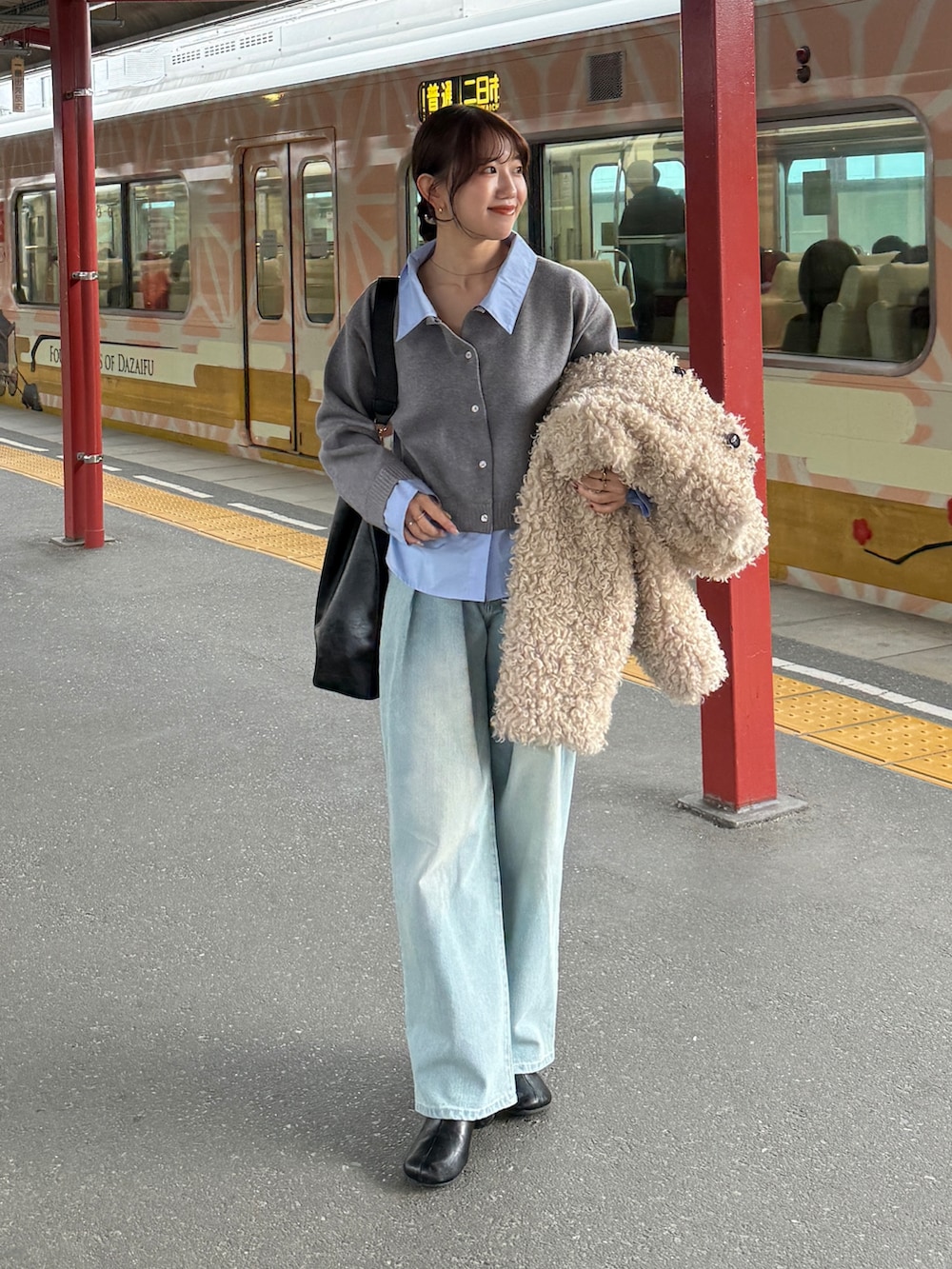 グレー系のニット/セーター、ブルー系のデニムパンツ、ホワイト系のブルゾンを着用したレディースの冬コーディネートの2枚目の写真