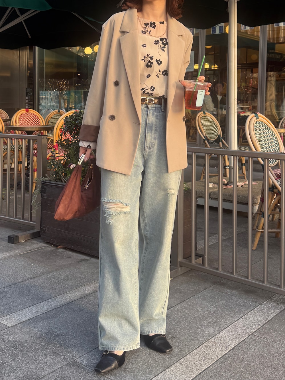 ベージュ系のテーラードジャケット、ホワイト系のシャツ/ブラウス、ブルー系のデニムパンツを着用したレディースの春コーディネートの2枚目の写真