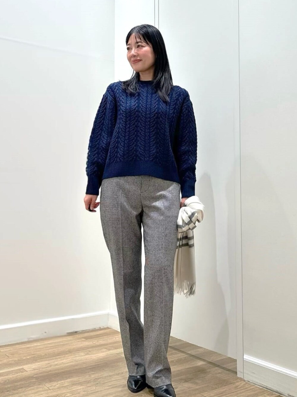 ブルー系のニット/セーター、グレー系のその他パンツ、ホワイト系のストール/ショールを着用したレディースの冬コーディネートの2枚目の写真