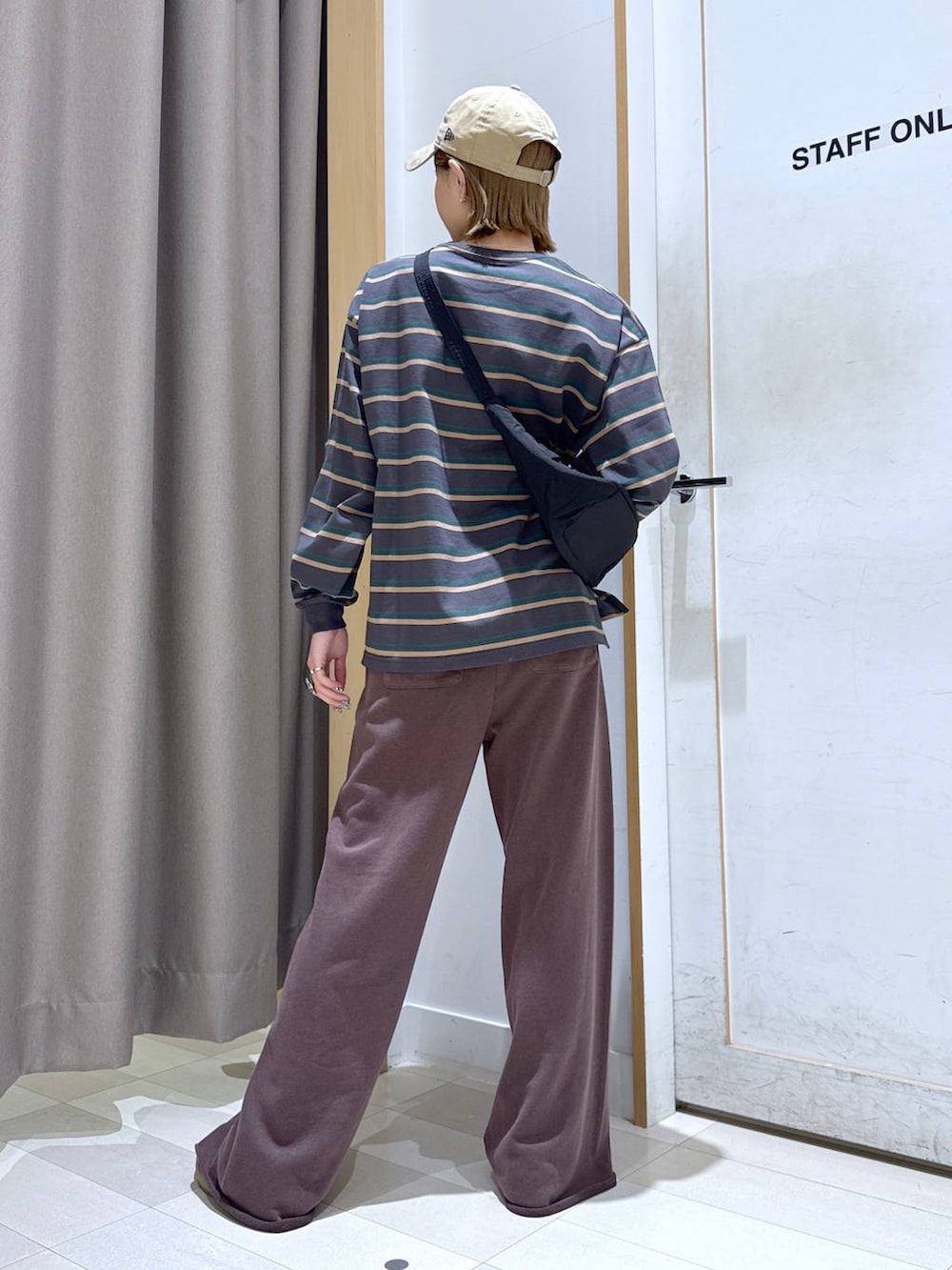 ベージュ系のスニーカー、ブラウン系のスウェットパンツ、グレー系のTシャツ/カットソーを着用したレディースの春コーディネートの3枚目の写真