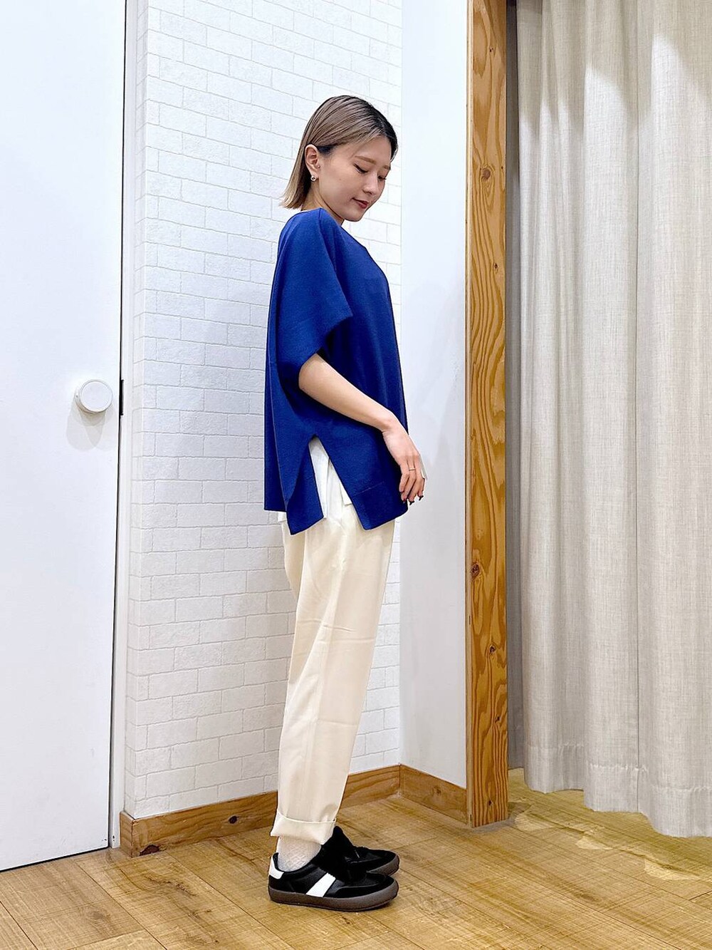 ホワイト系のその他パンツ、ブラック系のスニーカー、ブラウン系のトートバッグを着用したレディースの春コーディネートの2枚目の写真