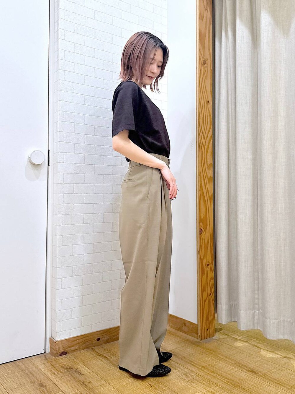 ブラック系のショルダーバッグ、ブラック系のパンプス、ブラウン系のニット/セーターを着用したレディースの春コーディネートの2枚目の写真