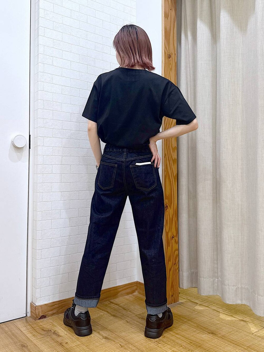 ブラック系のTシャツ/カットソー、ブルー系のデニムパンツ、グリーン系のボストンバッグを着用したレディースの春コーディネートの3枚目の写真