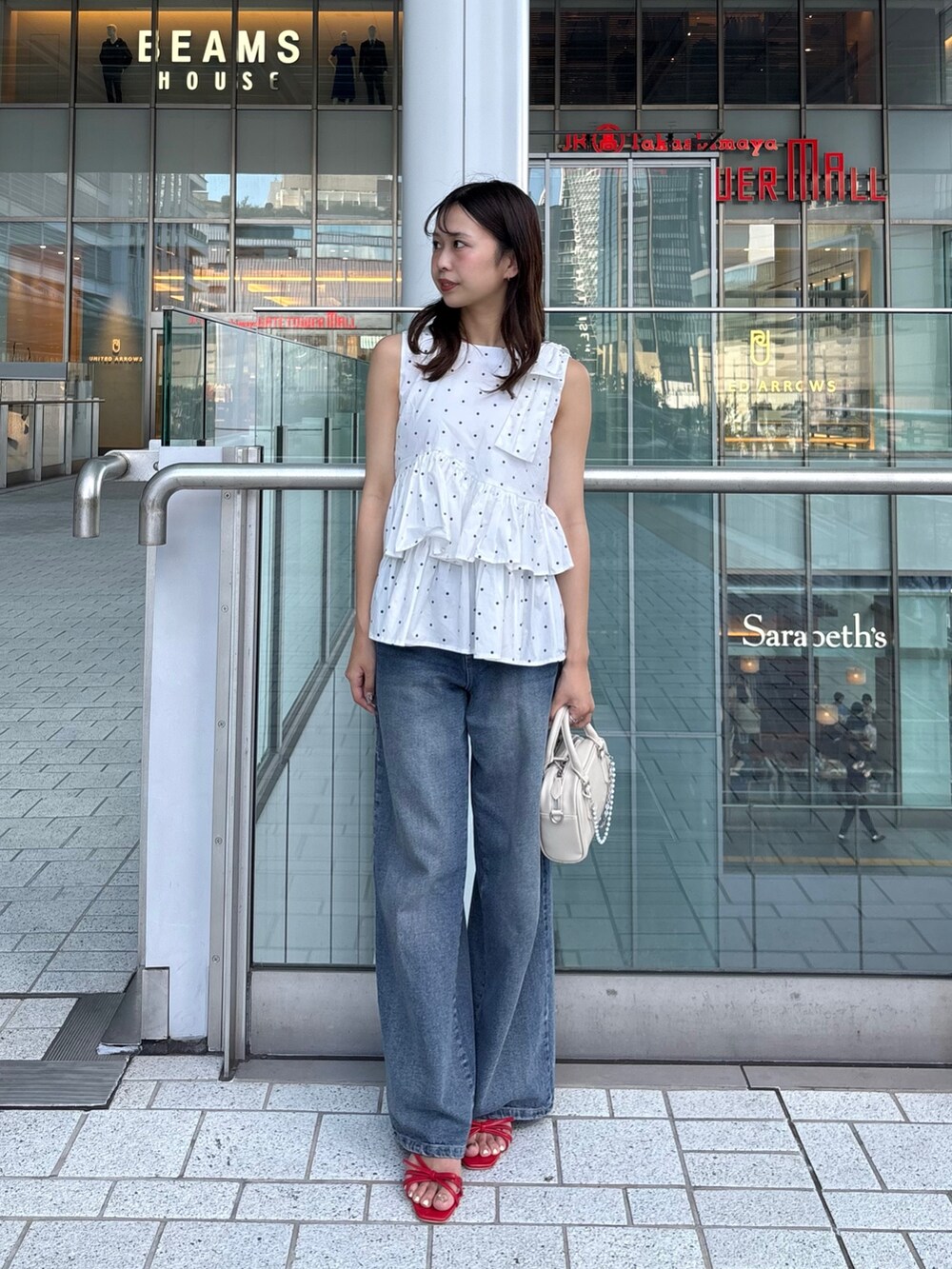 ホワイト系のシャツ/ブラウス、ブルー系のデニムパンツ、ホワイト系のボストンバッグを着用したレディースの夏コーディネートの3枚目の写真