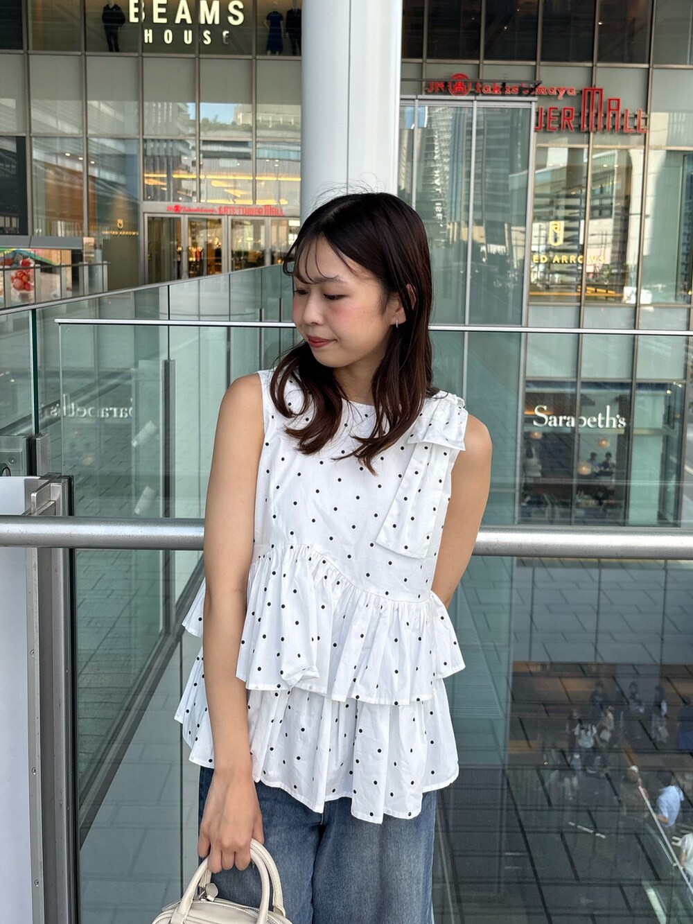 ホワイト系のシャツ/ブラウス、ブルー系のデニムパンツ、ホワイト系のボストンバッグを着用したレディースの夏コーディネートの4枚目の写真