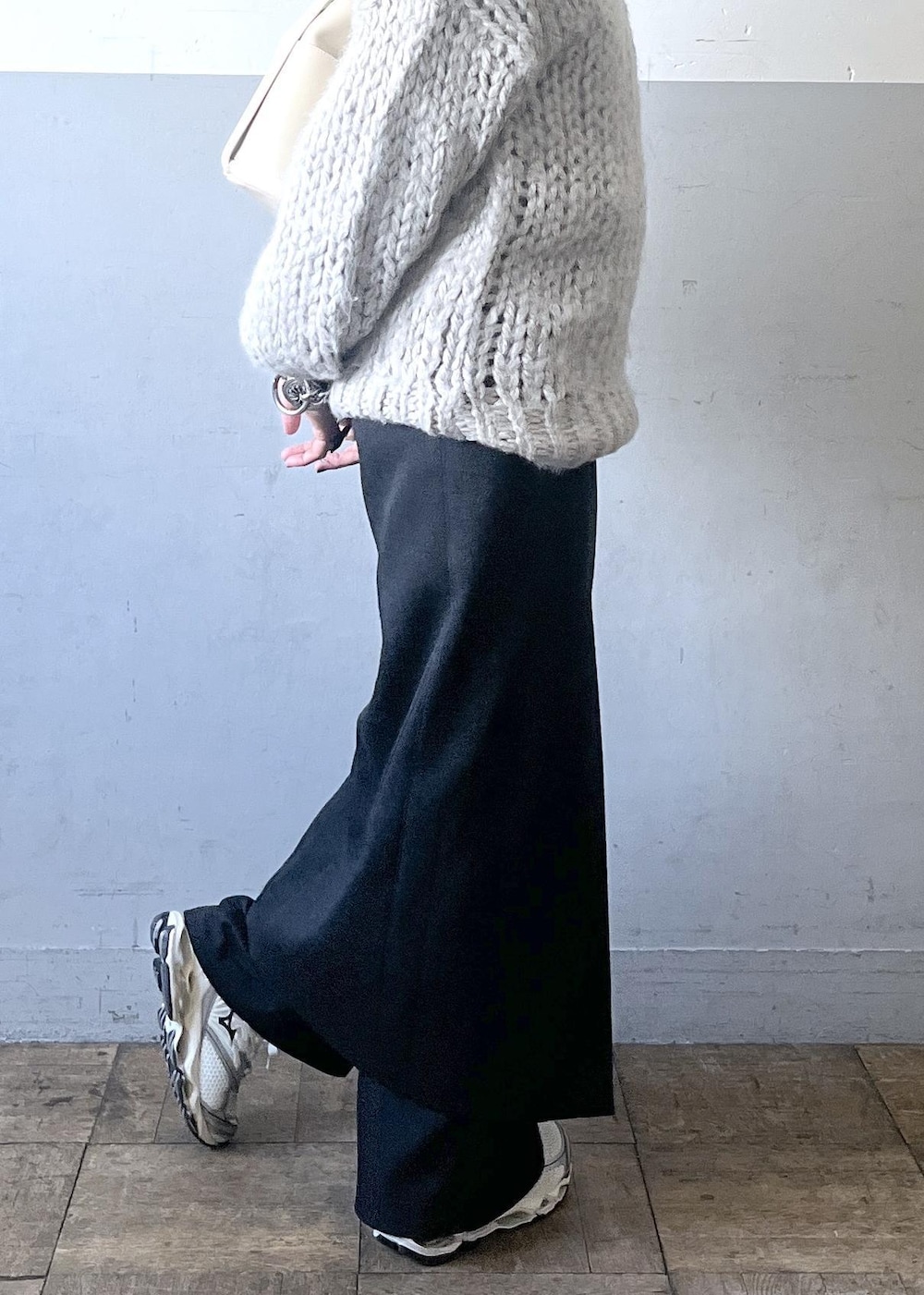 ブラック系のスカート、ホワイト系のショルダーバッグ、ホワイト系のスニーカーを着用したレディースの冬コーディネートの7枚目の写真