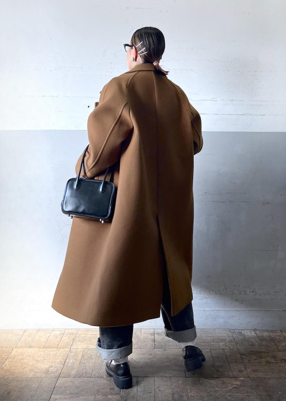 イエロー系のステンカラーコートを着用したレディースの秋コーディネートの5枚目の写真