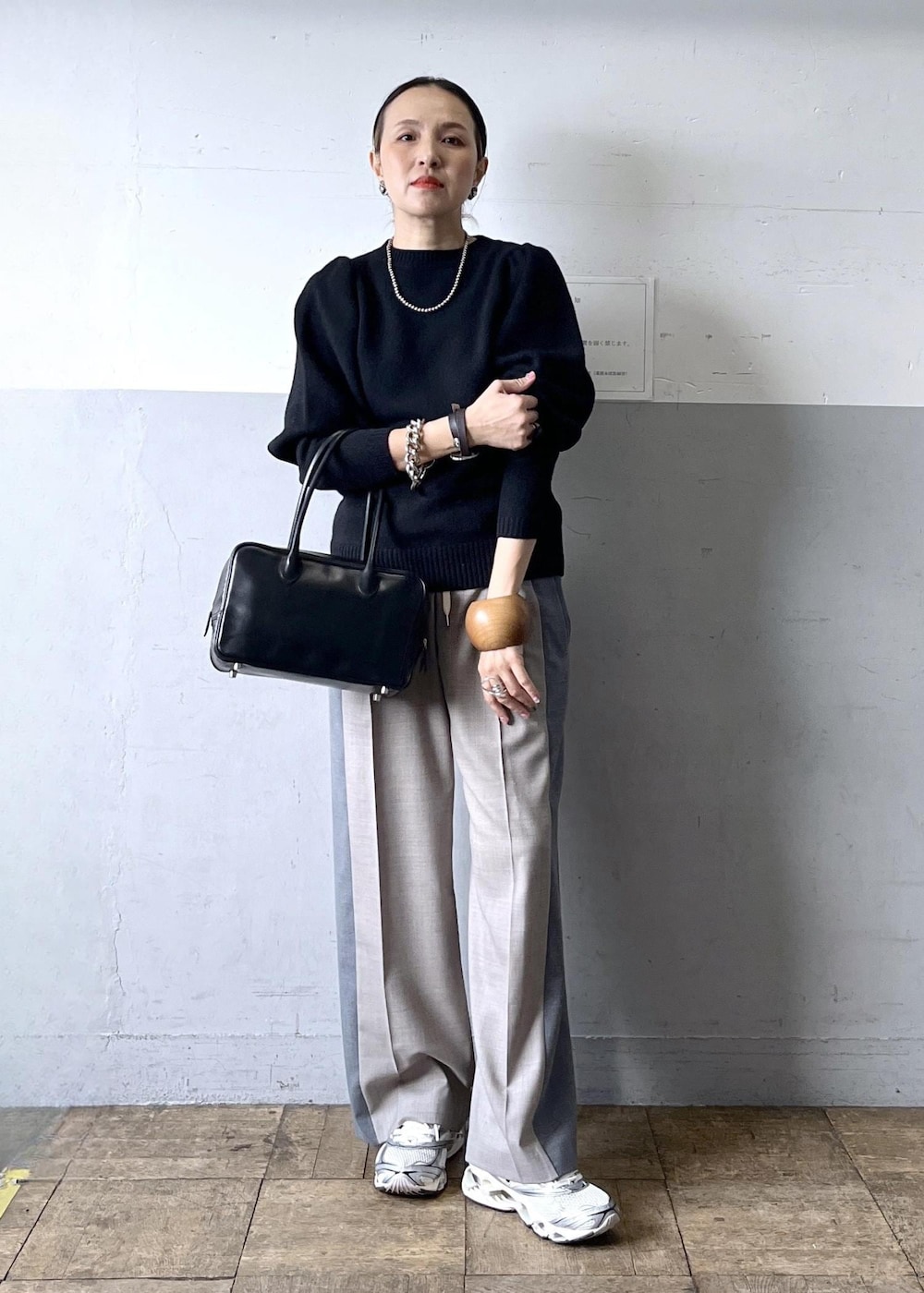 グレー系のその他パンツ、ブラック系のニット/セーター、ホワイト系のスニーカーを着用したレディースの冬コーディネートの2枚目の写真