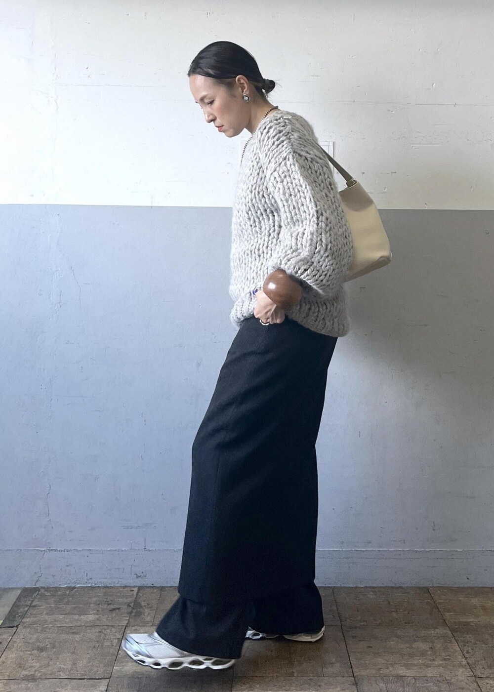 ブラック系のスカート、ホワイト系のショルダーバッグ、ホワイト系のスニーカーを着用したレディースの冬コーディネートの9枚目の写真