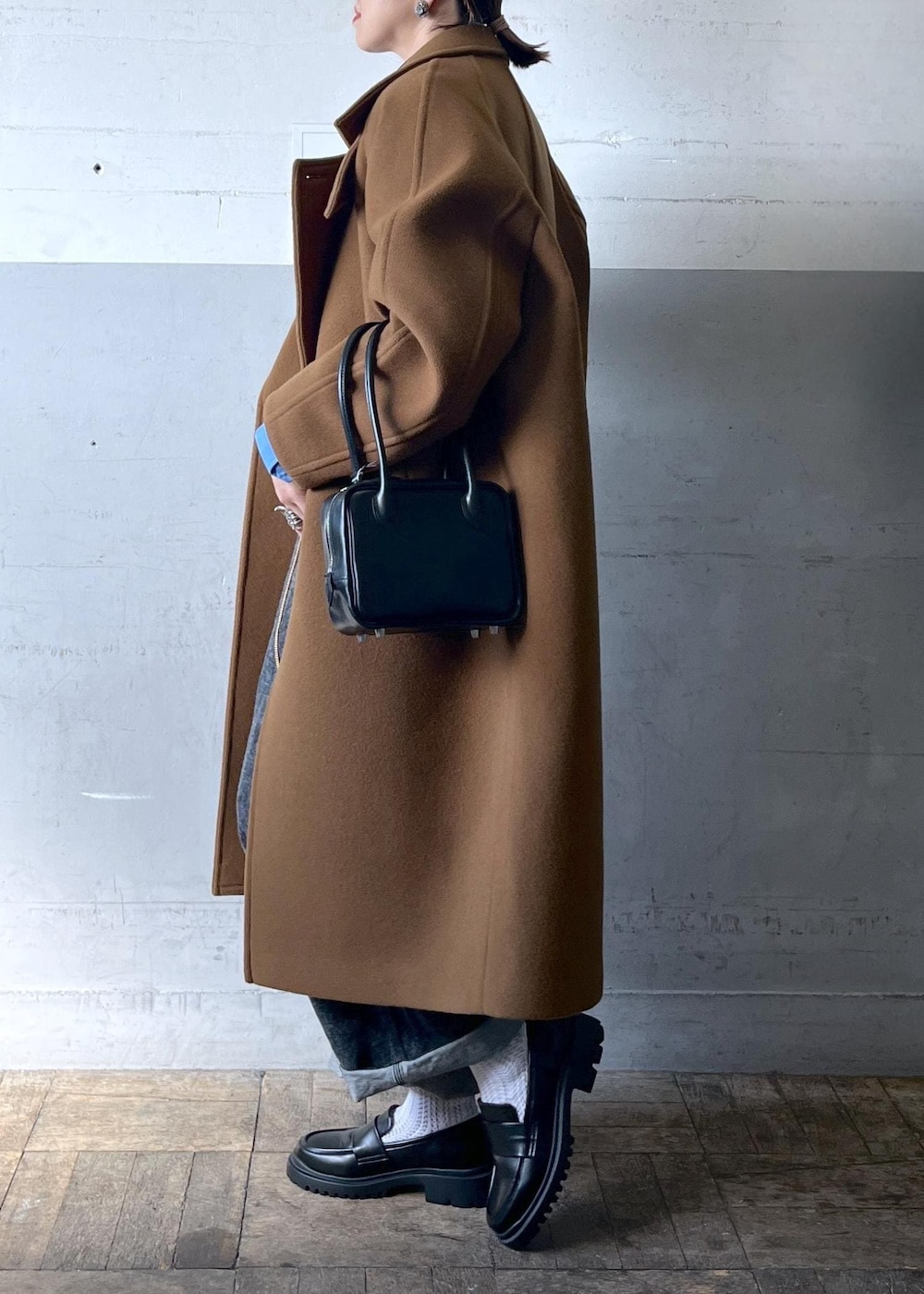 イエロー系のステンカラーコートを着用したレディースの秋コーディネートの4枚目の写真